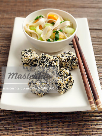 Deep fried tofu coated in black and white sesame seeds rice noodles stir fried vegetables carrots scallions sugar snaps Japanese main meals