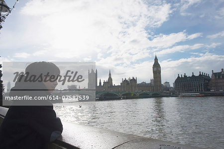 Boy by River Thames, Palace of Westminster in background, London