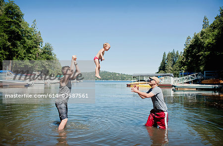 Female toddler thrown and caught mid air by young men