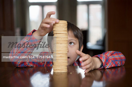 Boy stacking up biscuits