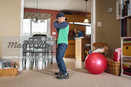 Portrait of boy practicing baseball in sitting room