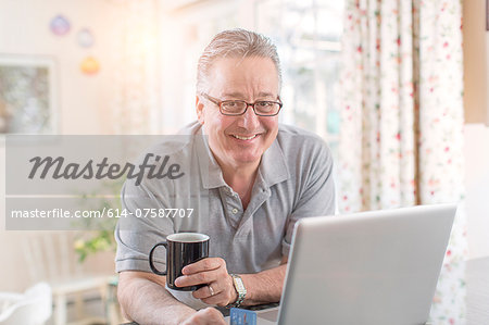 Mature man at home using laptop