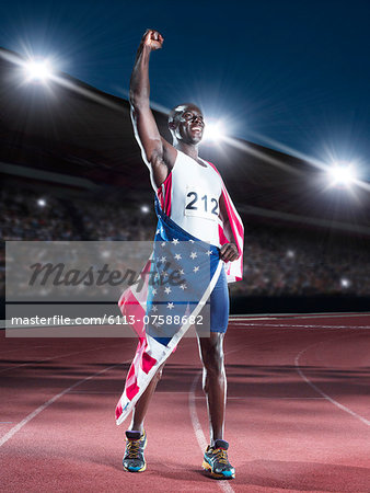 Track and field athlete wrapped in American flag on track