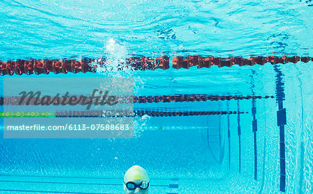 Swimmer smiling underwater in swimming pool