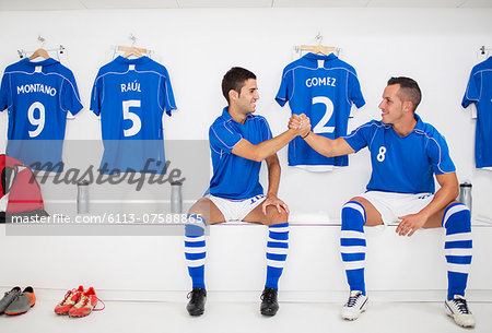 Soccer players shaking hands in locker room