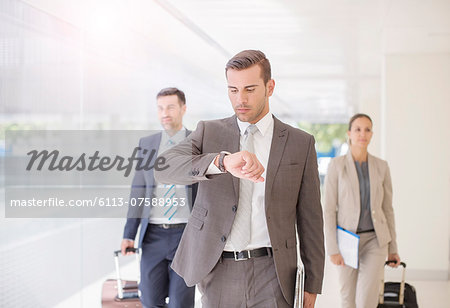 Business people with suitcases walking in corridor