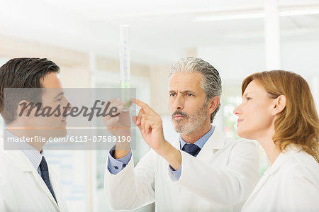 Scientists watching green liquid in tube