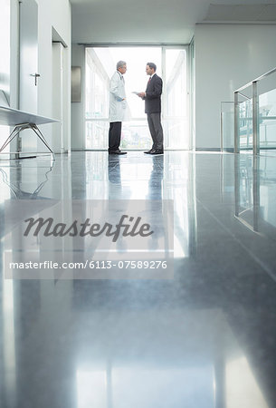 Doctor and administrator talking in hospital corridor