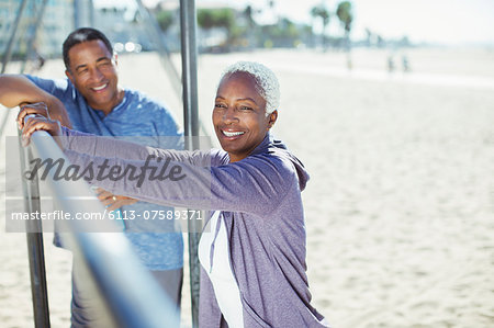 Portrait of senior couple leaning on bar at beach playground Portrait of senior couple leaning on bar at beach playground