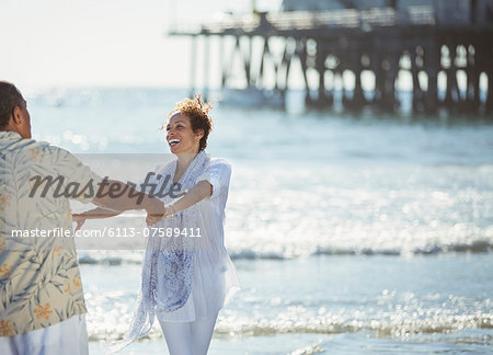 Enthusiastic couple dancing on sunny beach