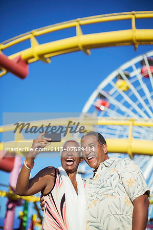 Senior couple taking selfie at amusement park