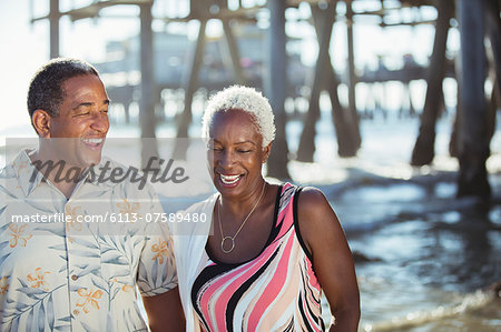 Senior couple on beach near pier