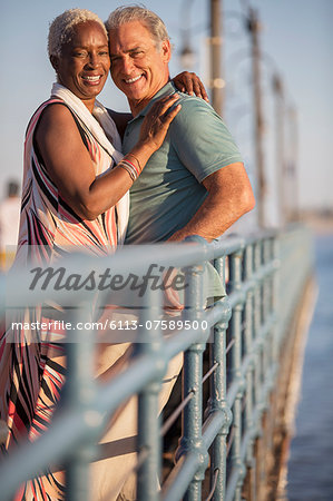 Portrait of smiling senior couple hugging on pier