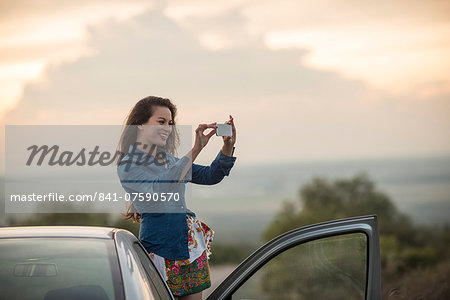 Young woman taking picture with her phone, Mineral de Pozos, Guanajuato, Mexico, North America