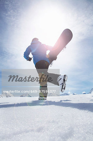 Mature man carrying his snowboard uphill, Obergurgl, Austria