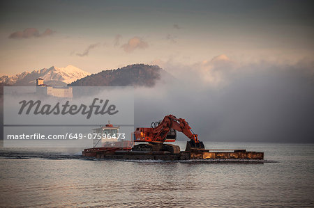 Excavator on barge,  Lake Maggiore, Varese, Piemonte, Italy