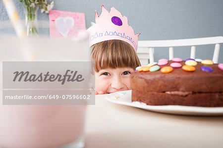 Girl hiding behind cake