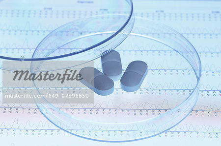 Genetic research. Pills in a Petri dish on the screen of a tablet computer that displays results of automated DNA sequencing Genetic research. Pills in a Petri dish on the screen of a tablet computer that displays results of automated DNA sequencing