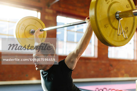 Man lifting weights in gymnasium