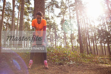 Mature woman runner taking a break in a forest Mature woman runner taking a break in a forest