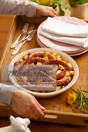 Sausages on fried potatoes with cranberries