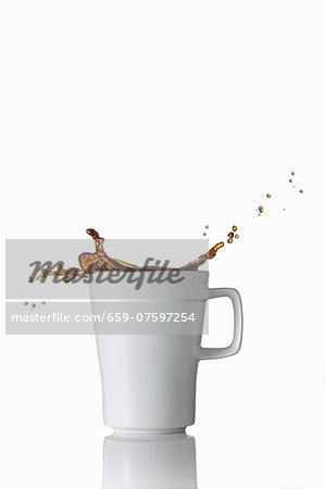 Black coffee splashing out of the mug Black coffee splashing out of the mug