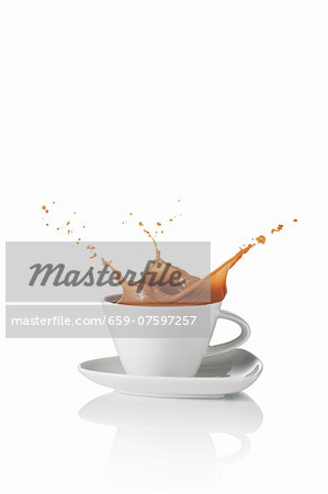 A latte splashing out of the cup