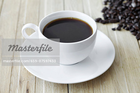 Black coffee in a white cup and coffee beans Black coffee in a white cup and coffee beans