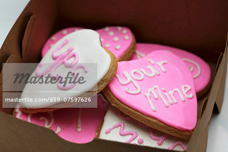 Small gingerbread hearts decorated with white and pink glacé icing