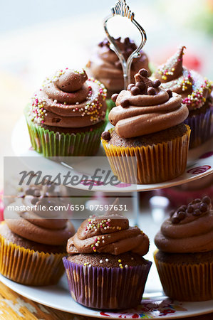 Chocolate cupcakes with sugar pearls on a tiered cake stand Chocolate cupcakes with sugar pearls on a tiered cake stand