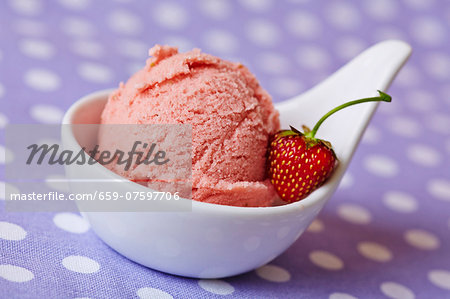 Home-made strawberry ice cream with a strawberry in a bowl