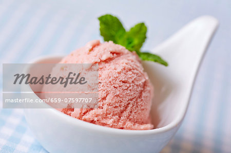 A scoop of home-made raspberry ice cream with mint leaves