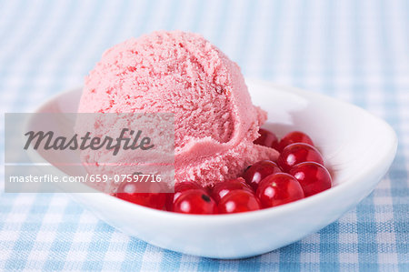 A scoop of home-made redcurrant ice cream with redcurrants A scoop of home-made redcurrant ice cream with redcurrants