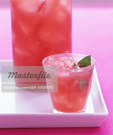 A blood orange drink with ice cubes and mint A blood orange drink with ice cubes and mint