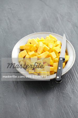 Diced squash on a plate with a knife