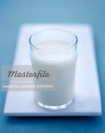 A glass of milk on a white serving platter