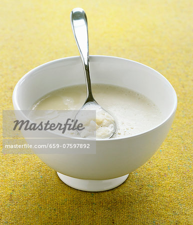 Cauliflower soup in a bowl with a spoon