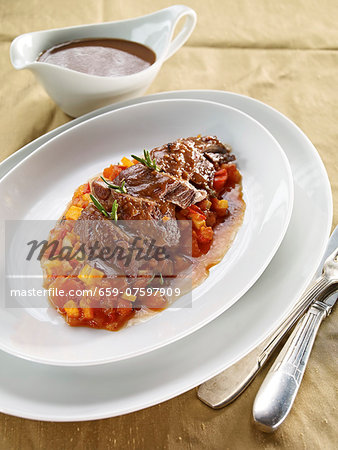 Pot-roasted shoulder of lamb with carrots and peppers