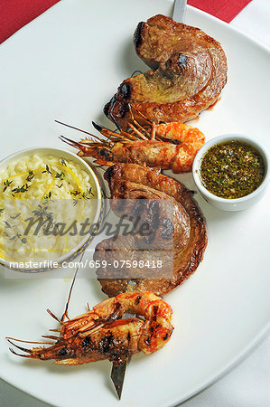 A skewer of barbecued beef and prawns, with lemon risotto