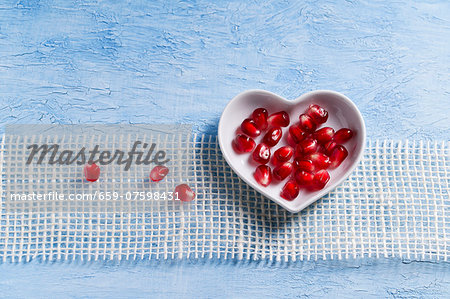 Pomegranate seeds in a heart-shaped bowl