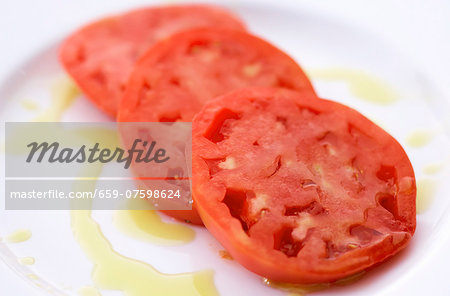 Sliced Tomatoes on a White Plate Drizzled with Olive Oil