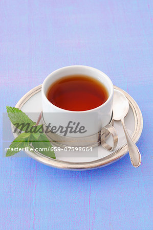 A cup of peppermint tea with a sprig of mint A cup of peppermint tea with a sprig of mint