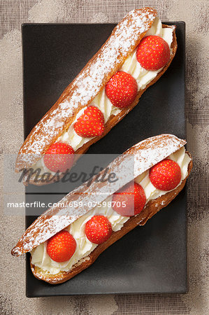 Eclairs with cream and strawberries