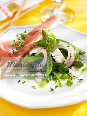 Raw ham with bread sticks and green vegetable salad