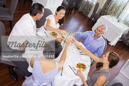 Business colleagues toasting wine glasses around table