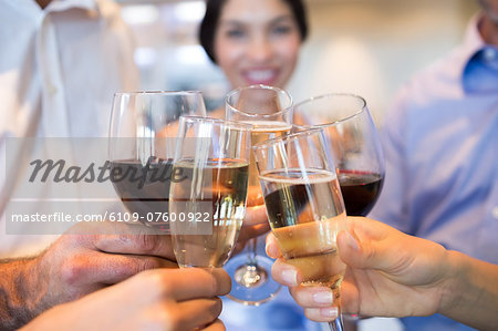 Closeup mid section of people toasting wine glasses