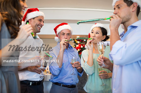 People in Santas hats with champagne flutes and noise makers