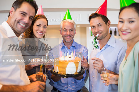 Happy group of people with champagne flutes and cake