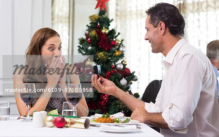 Man proposing a surprised woman in the restaurant