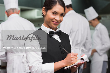 Happy waitress writing on pad